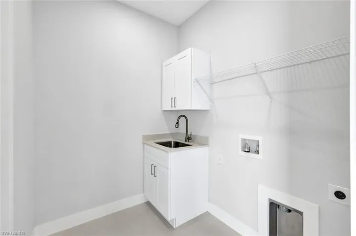 Laundry area featuring hookup for an electric dryer, hookup for a washing machine, and cabinet space