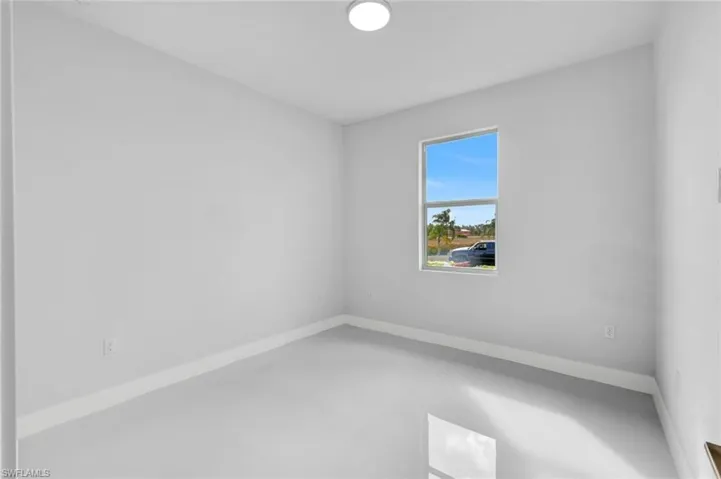 Empty room featuring baseboards and concrete flooring