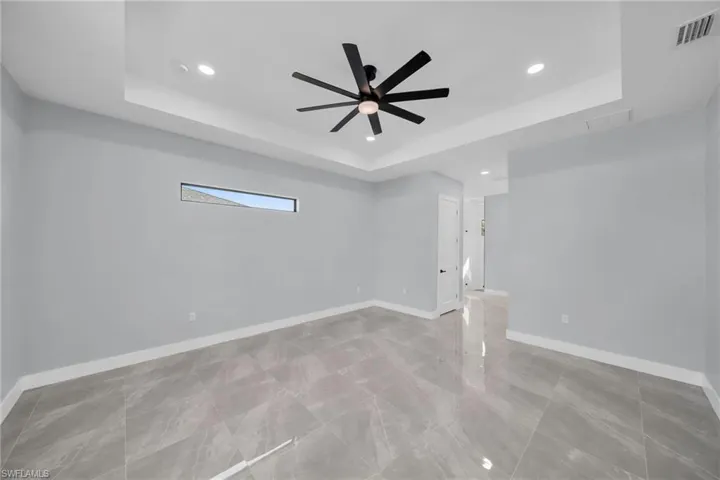 Spare room with ceiling fan and a tray ceiling
