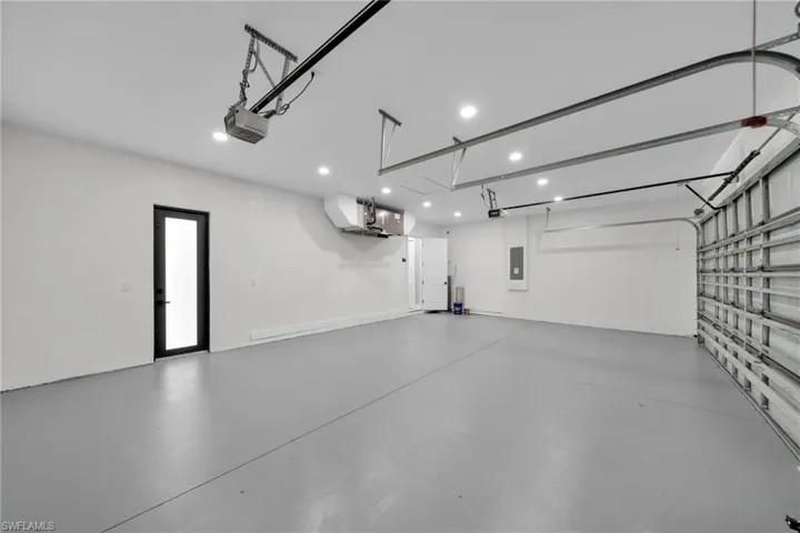 Garage featuring a garage door opener and electric panel