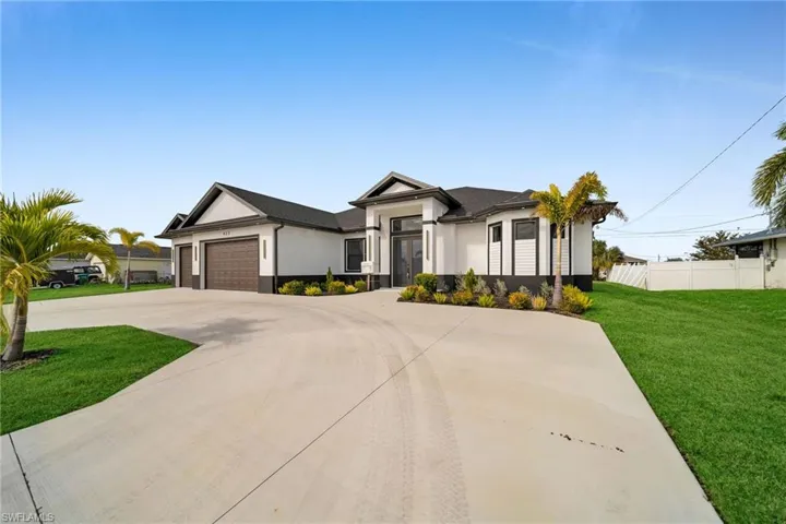 View of front of property featuring a front yard and a garage