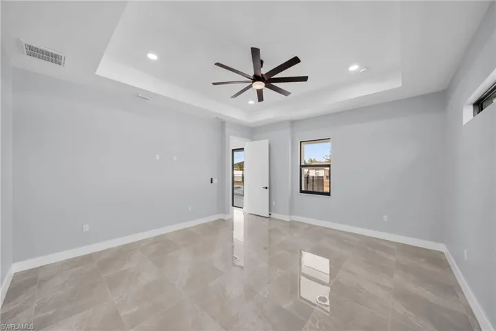 Spare room featuring ceiling fan and a tray ceiling