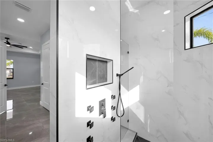 Bathroom with ceiling fan and a shower