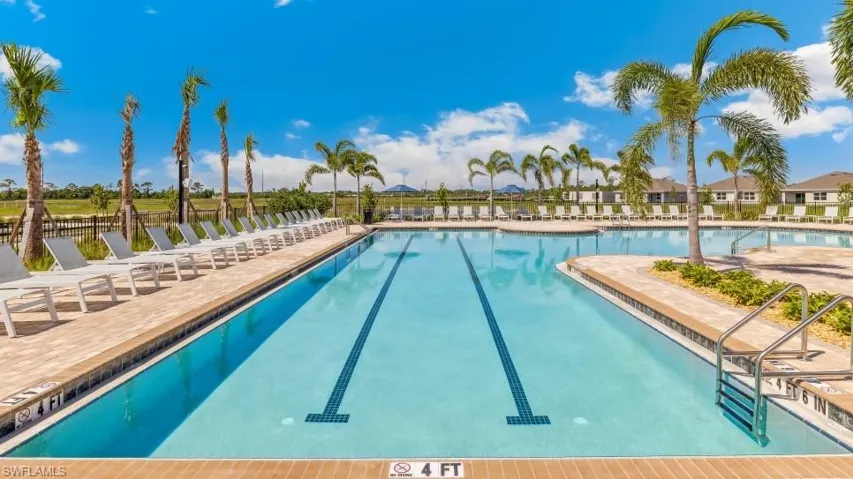 The property features a swimming pool with lane markers, surrounded by a paved deck with lounge chairs