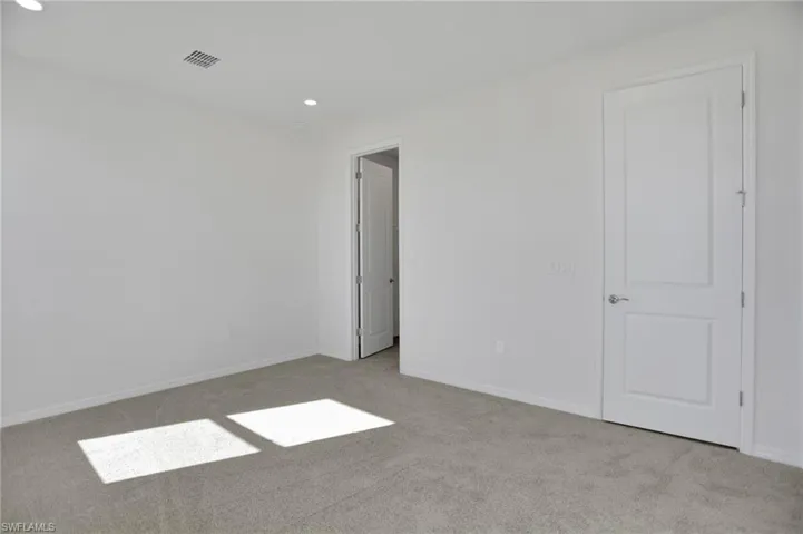 Unfurnished bedroom featuring light colored carpet and recessed lighting