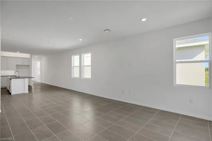 Unfurnished living room featuring recessed lighting and light tile patterned floors
