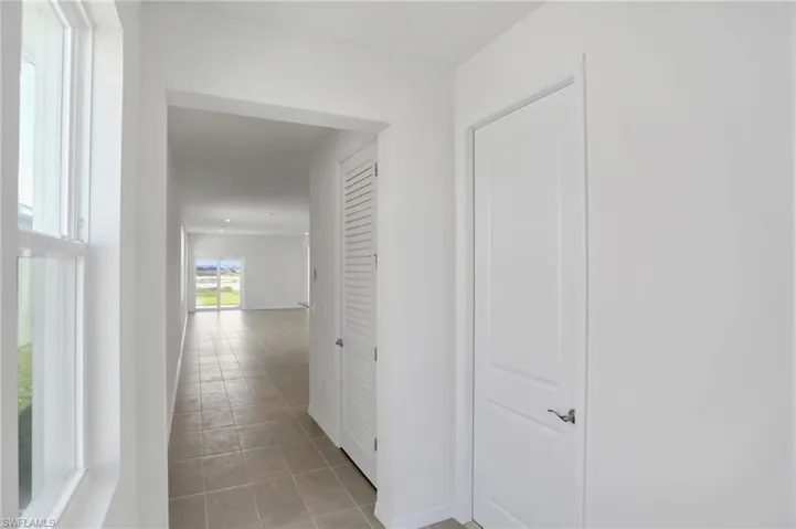 Corridor with light tile patterned floors and baseboards