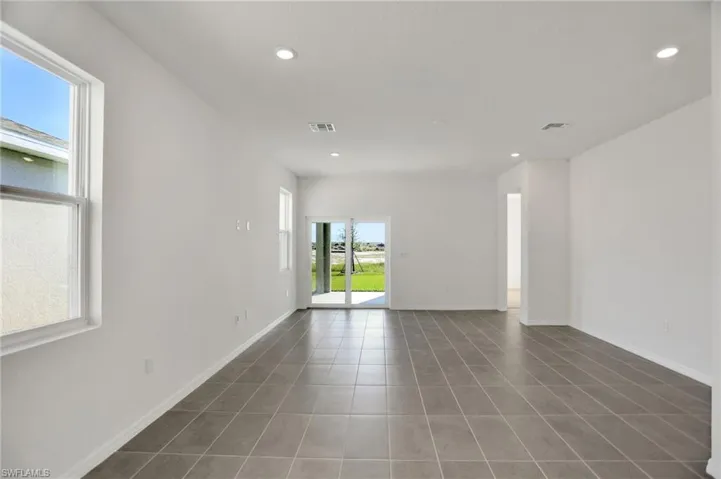 Unfurnished room featuring recessed lighting and dark tile patterned floors