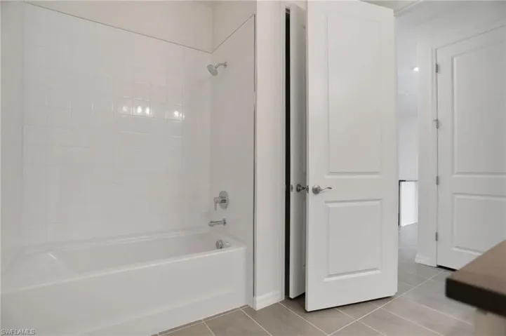 Bathroom featuring shower / bath combination and light tile patterned floors