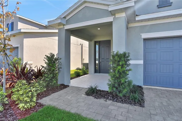 Entrance to property with stucco siding and a garage