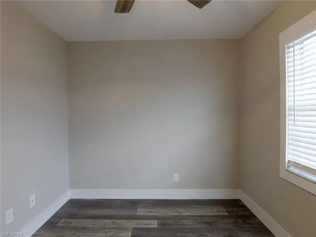 Spare room featuring dark wood-style floors and a ceiling fan