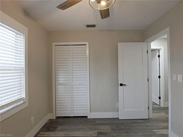 Unfurnished bedroom with dark wood finished floors, a closet, and ceiling fan