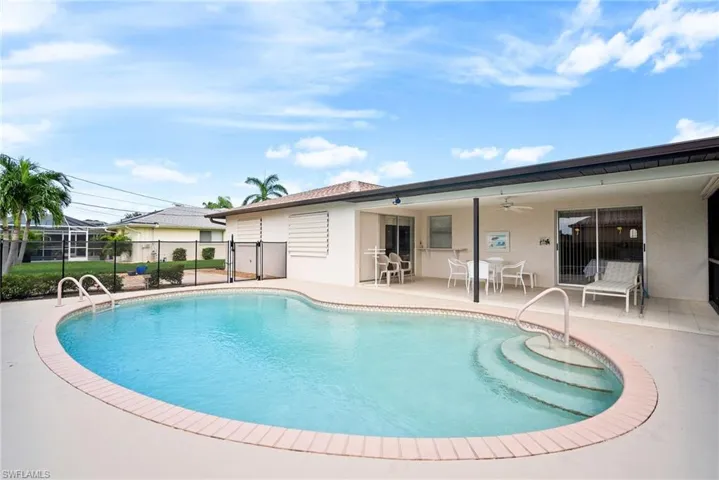 View of pool with a lanai, ceiling fan, and a patio area