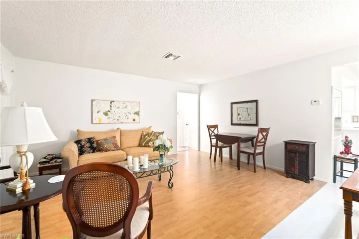 Living room with light hardwood / wood-style floors and a textured ceiling