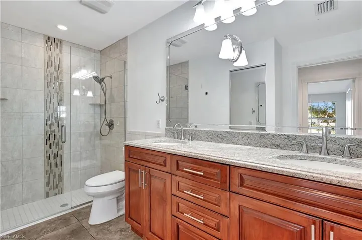 Actual condition of cabinets color in Master  bath. It  has double vanity, a stall shower, recessed lighting.