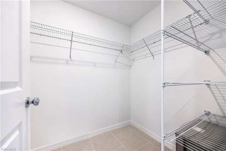 Spacious closet with light tile patterned floors