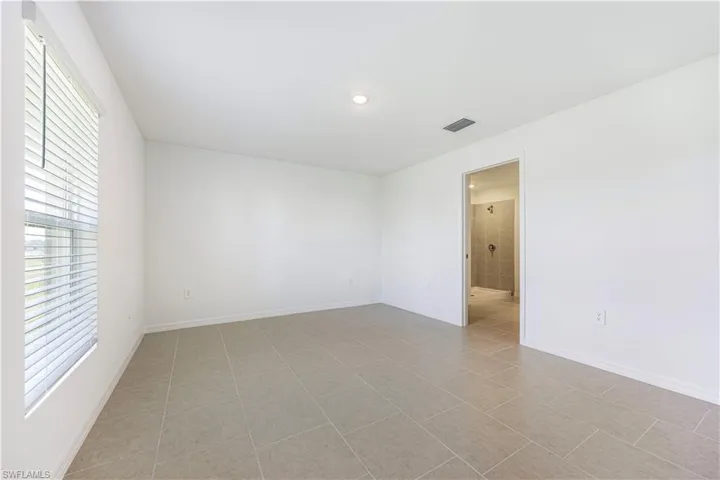 Empty room with light tile patterned floors and baseboards