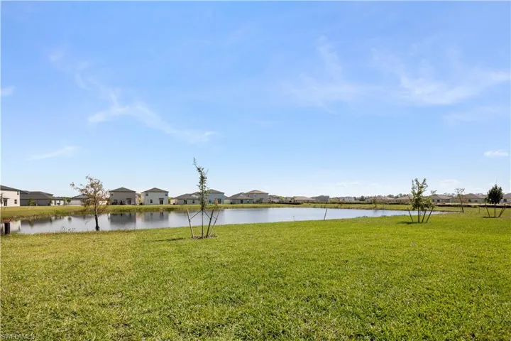 View of grassy yard featuring a water view and a residential view