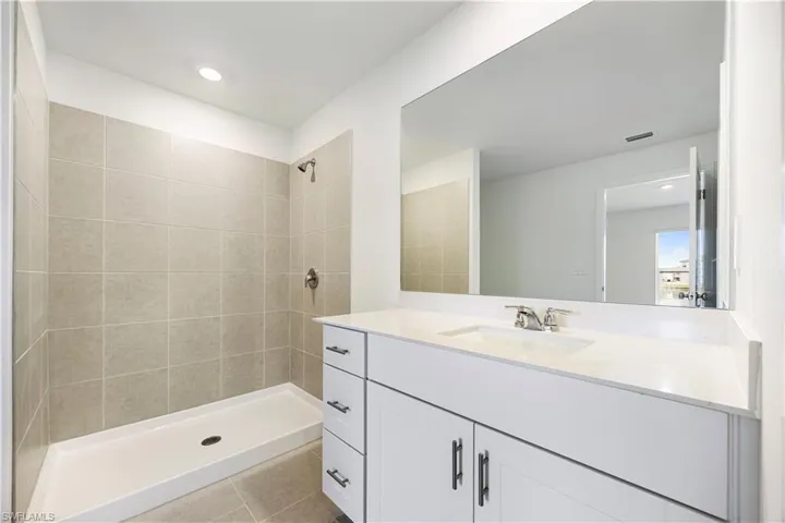 Bathroom with vanity, a shower stall, light tile patterned flooring, and recessed lighting