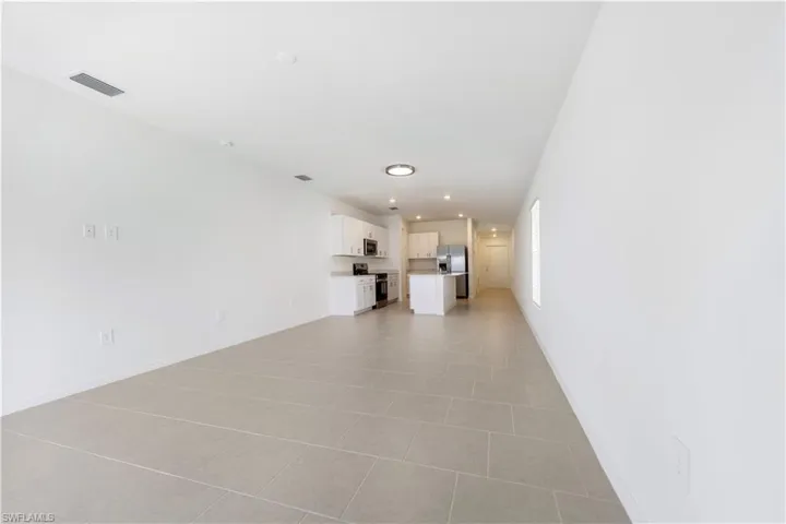 Unfurnished living room with recessed lighting and light tile patterned floors