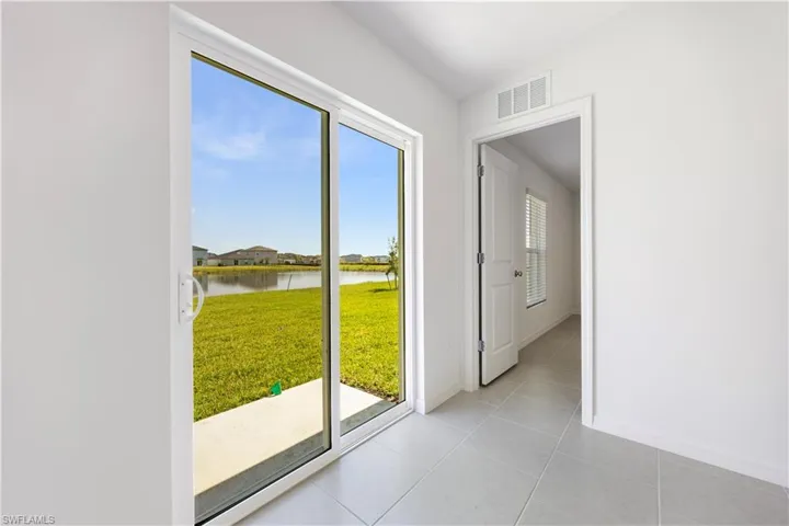 Doorway featuring a water view and tile patterned floors