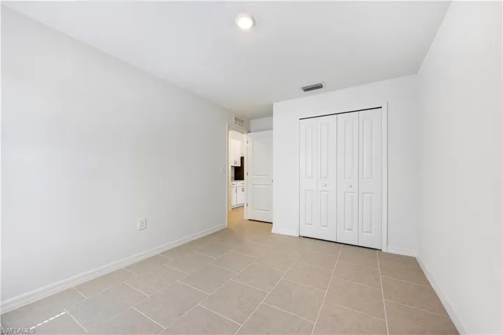 Unfurnished bedroom featuring a closet and light tile patterned flooring