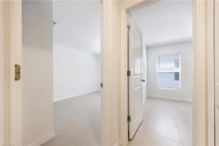 Corridor with baseboards and light tile patterned floors
