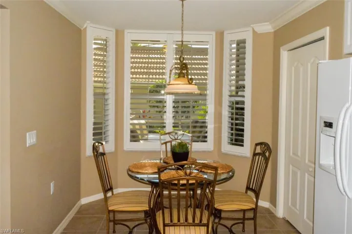 Dining space featuring crown molding and dark tile patterned floors