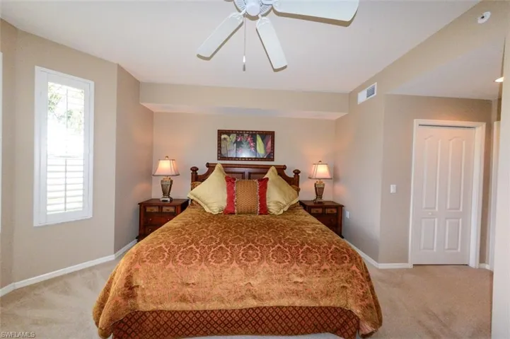 Bedroom with light colored carpet and ceiling fan