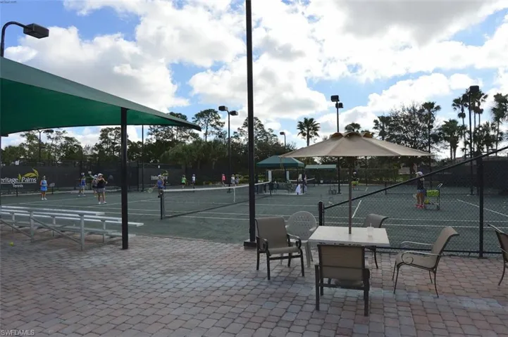View of tennis court with a patio