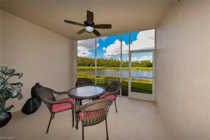 Sunroom featuring ceiling fan, outdoor dining area, and a water view