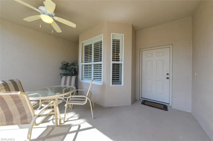 Doorway to property with outdoor dining space, a ceiling fan, and stucco siding