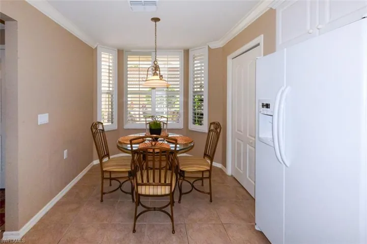 Dining room with ornamental molding and light tile patterned flooring