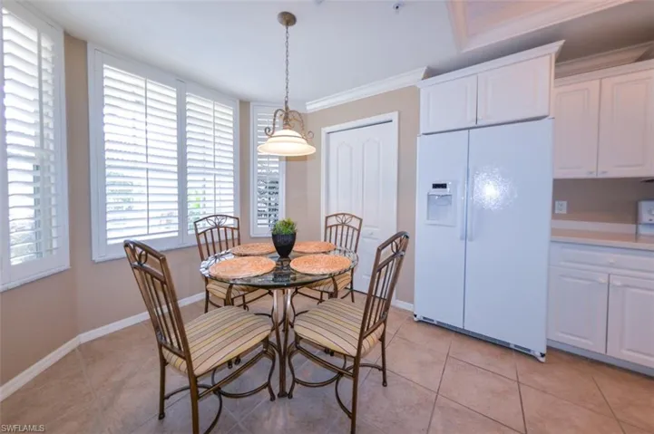 Dining area with ornamental molding and light tile patterned floors