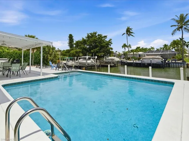 Rectangular swimming pool with integrated steps and a stainless steel handrail