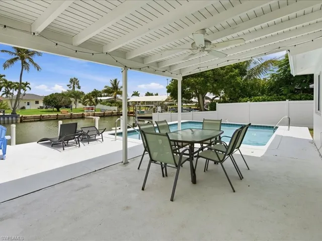 Covered patio area featuring a ceiling fan, string lighting, and a white planked ceiling