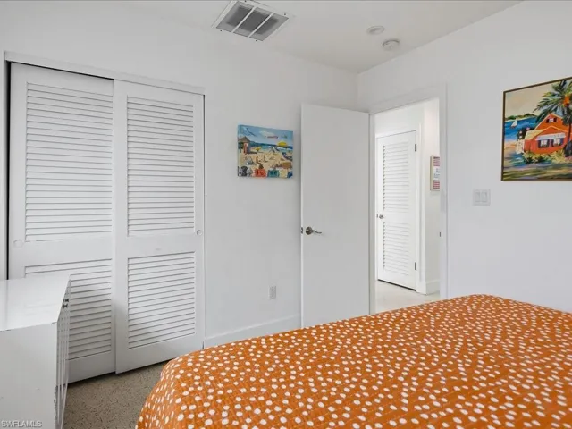 Louvered closet doors, recessed ceiling lighting, and light-colored wall-to-wall carpeting