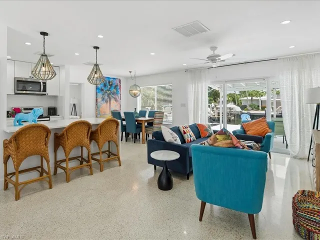 Open-concept living area featuring a kitchen island with seating, a dining space, and a living room