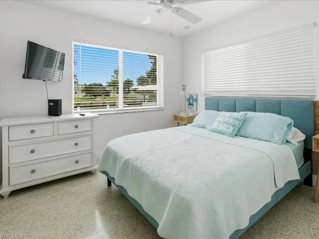 Bedroom featuring terrazzo flooring, a window with horizontal blinds, and a ceiling fan