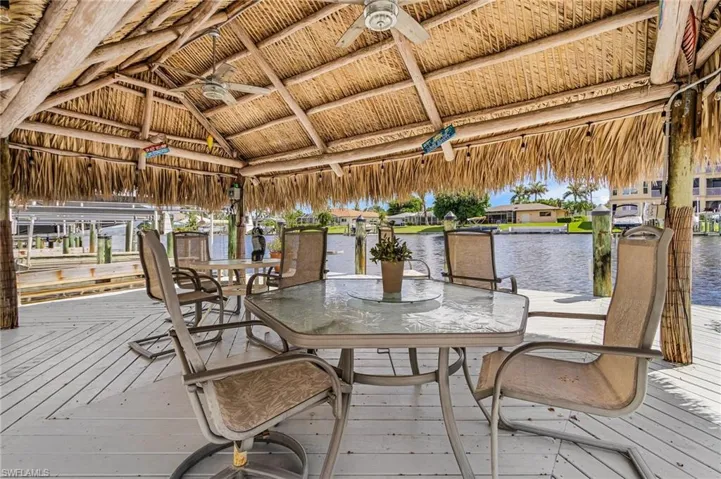 Wooden deck featuring ceiling fan and a water view