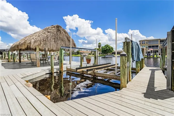 Dock featuring boat lift and a water view