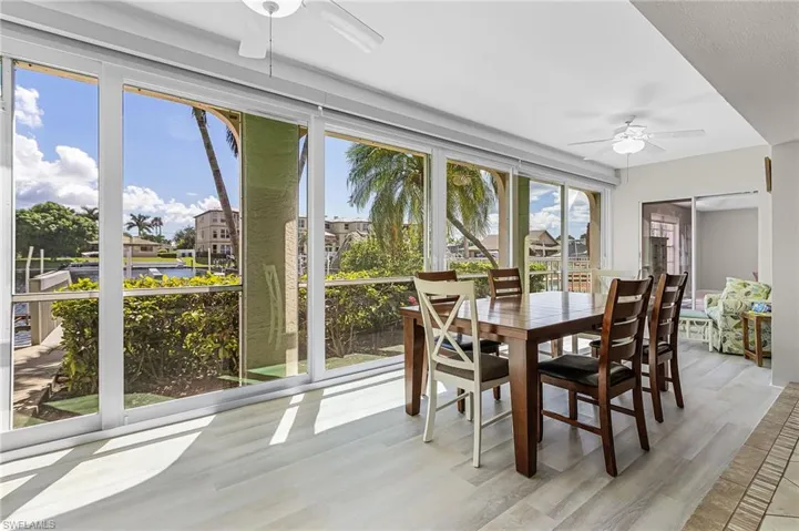 Sunroom with wood finished floors and a water view