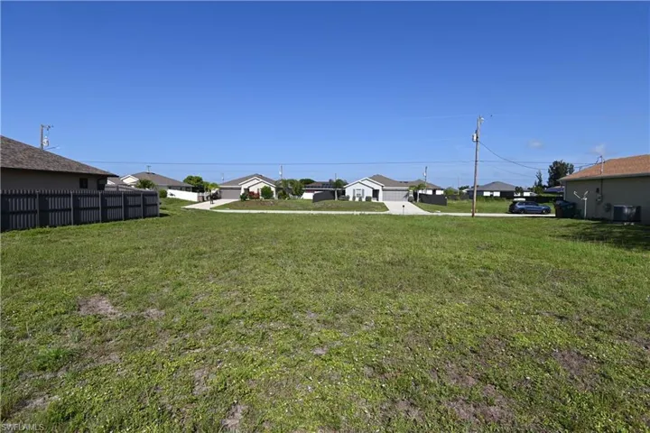 Expansive grassy lot with surrounding residential properties