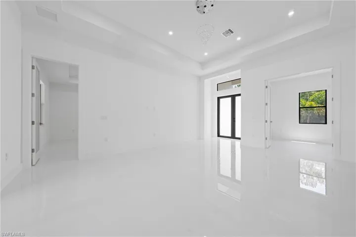 Unfurnished room with a tray ceiling, recessed lighting, and light tile patterned floors