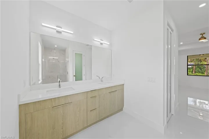 Full bathroom with a marble finish shower, double vanity, and recessed lighting