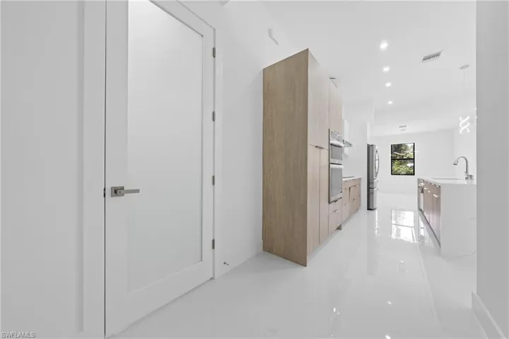 Hallway with light tile patterned floors and recessed lighting
