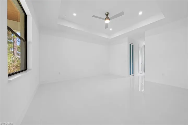 Empty room featuring a tray ceiling, recessed lighting, and a ceiling fan