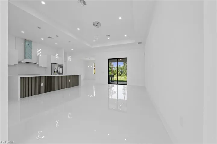 Unfurnished living room with recessed lighting and a raised ceiling