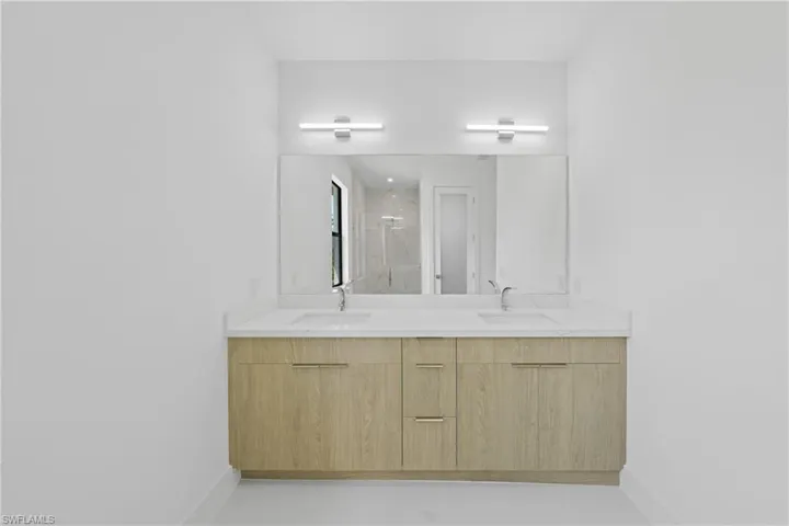 Bathroom with a marble finish shower and double vanity