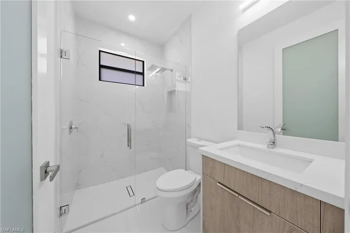 Bathroom with vanity and a marble finish shower